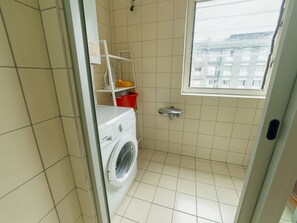 A compact laundry room with a Siemens washing machine, a drying rack, and a small window. - DOWNTOWN DELUXE 6 by VACATIONY by Interhome (Porto)