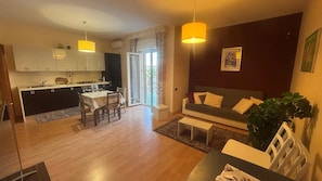 A modern apartment with a kitchen, dining area, and living room.