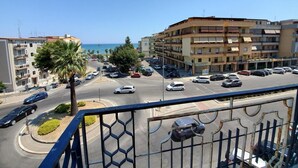 Un paisaje urbano costero con una glorieta, edificios de varios pisos y coches estacionados.