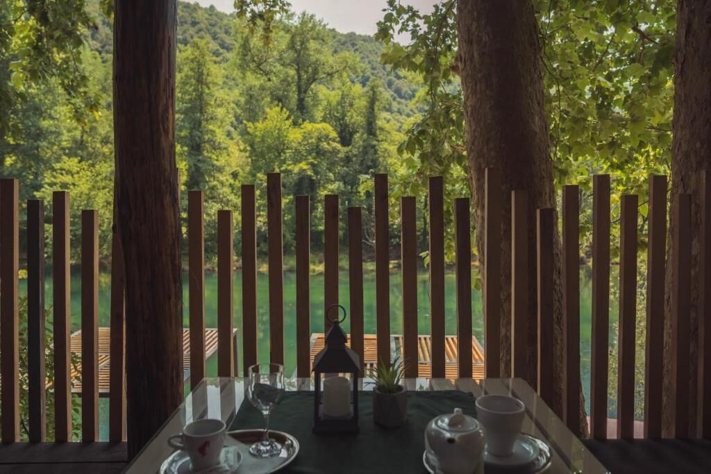 A table set for tea with a view of a forested area.