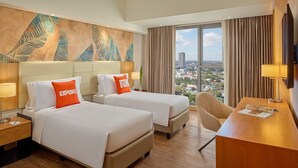 A hotel room with two beds, a desk, a chair, a large window with a city view, and a decorative wall. - Alino Hotel (Quezon City)