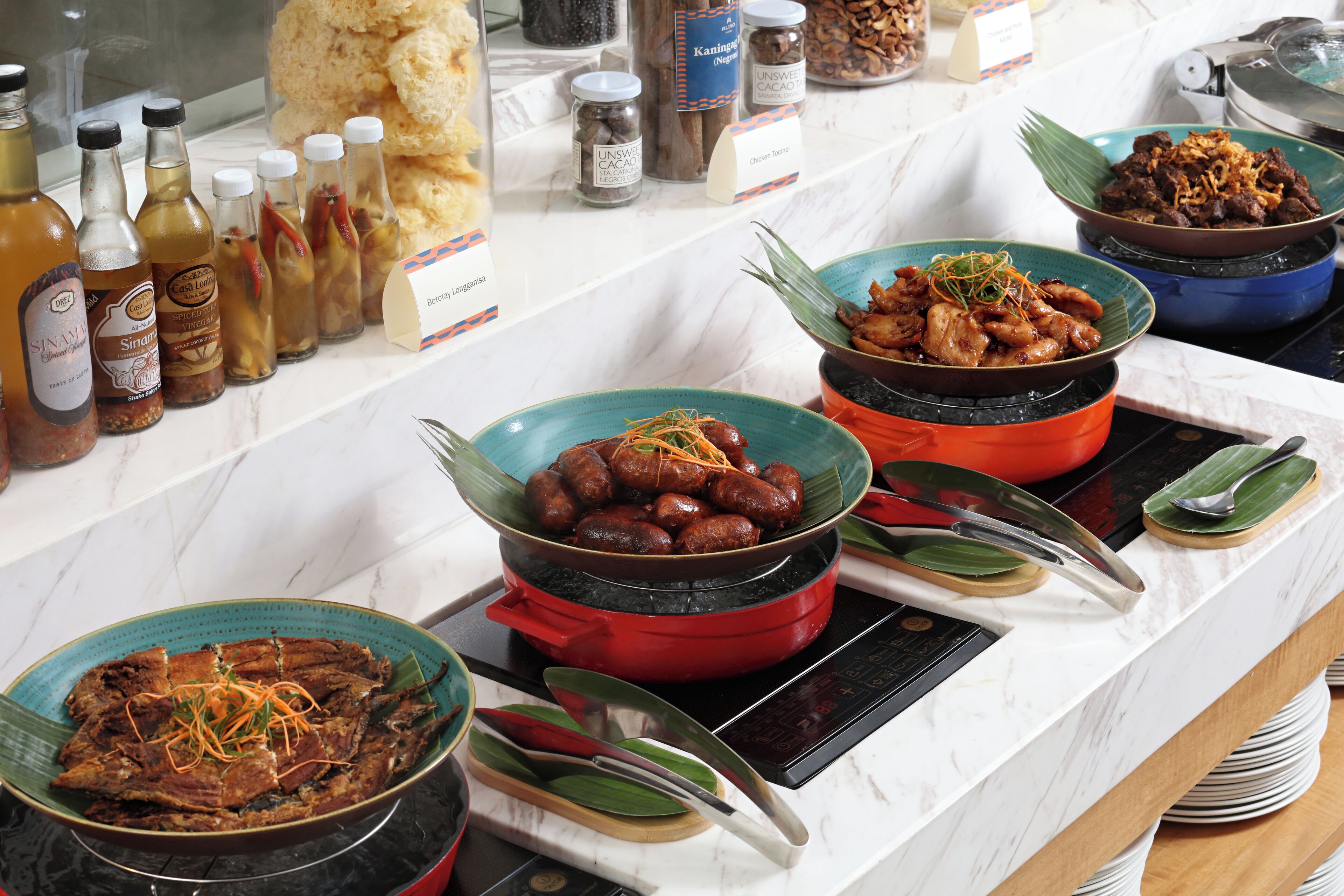 A buffet with various dishes and condiments.