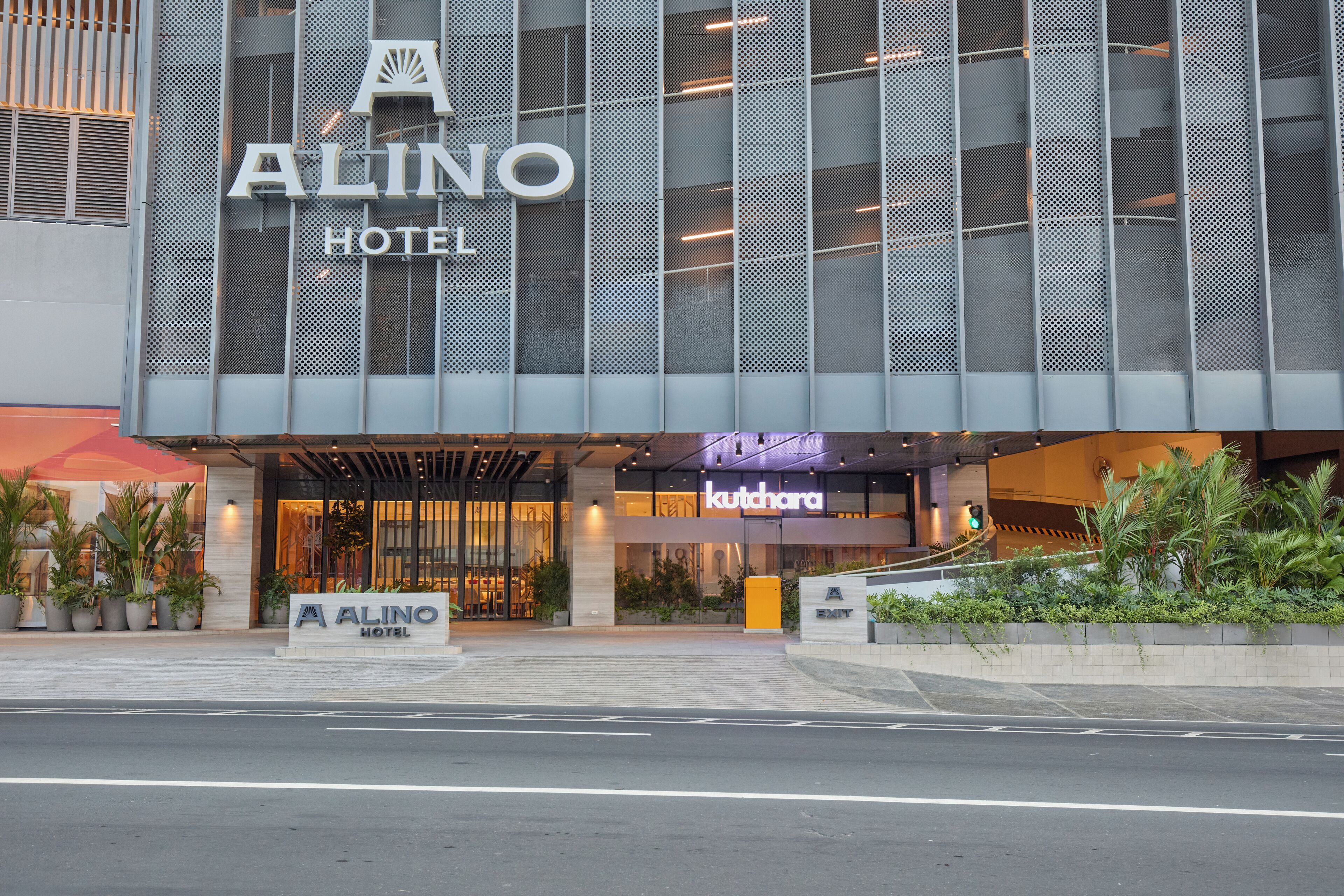 Fachada moderna de un hotel, con un cartel que dice 'Alino Hotel' y un restaurante 'Kutchara' debajo.