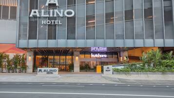 Fachada moderna de un hotel, con un cartel que dice 'Alino Hotel' y un restaurante 'Kutchara' debajo.