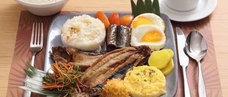 Un plato de comida con arroz, pescado, huevos y verduras.