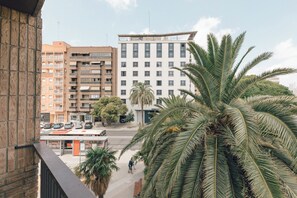 A multi-story hotel with a flat roof, a parking lot, and palm trees in the foreground. - Monlar Campanar (Valencia)
