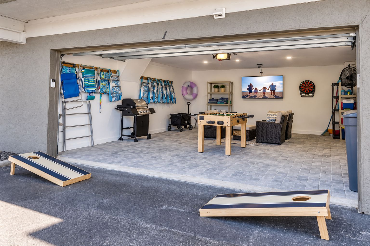 Un garage con un tavolo da calcio, una griglia per barbecue e un bersaglio da freccette.