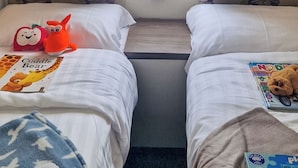 A double bed with a pillow and a book titled 'Cuddle Bear' on one side, and a teddy bear on the other. - Birch 3-bedroom Pet Friendly (Clynderwen)