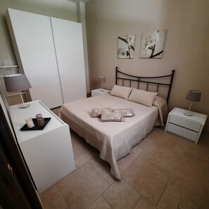 A bedroom with a bed, bedside tables, a wardrobe, and artwork on the wall. - MEST PEPP (Santa Teresa)