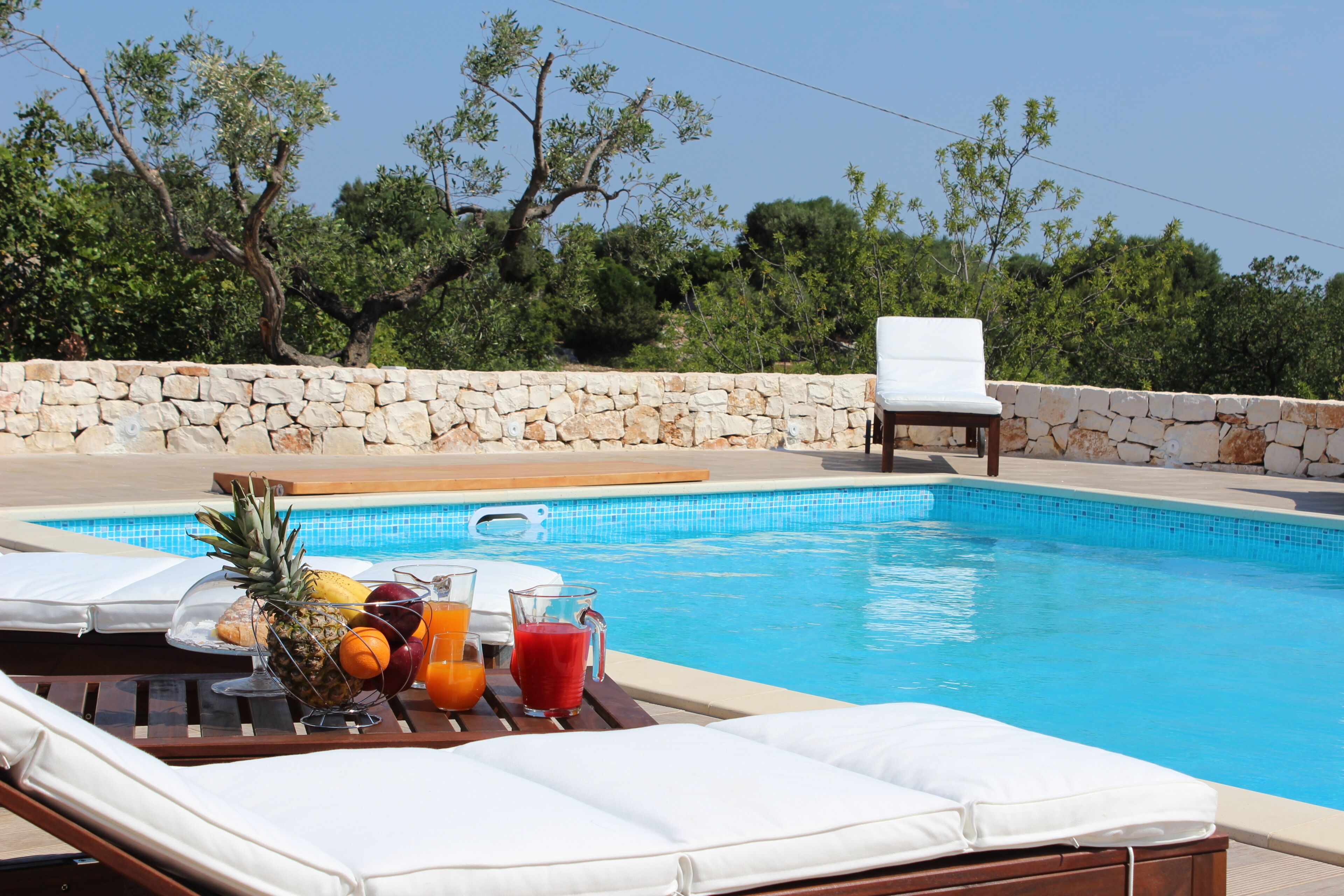 Una piscina al aire libre de temporada, sillones reclinables de piscina
