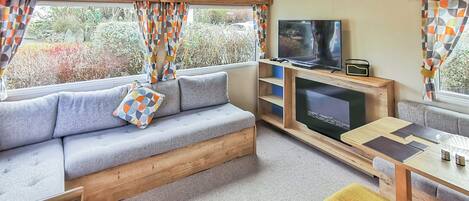 Un salon confortable avec un canapé, une télévision et des meubles en bois.