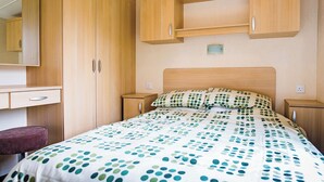 Ein Schlafzimmer mit einem Bett, einem Nachttisch, einer Kommode und einem Spiegel.