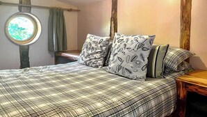 Ein Schlafzimmer mit einem Bett, Kissen, einem Fenster und einem hölzernen Kopfteil.