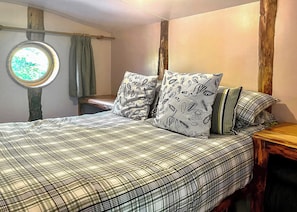 A bedroom with a bed, pillows, a window, and a wooden headboard. - Bronze Plus 3 Bed Pets Sleeps 6 (Clarach Bay, Nr Aberystwyth)