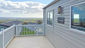 Ein Balkon mit Blick auf die Landschaft, ein Schild mit der Aufschrift 'Coworth' und ein Metallgeländer.