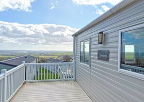 A balcony with a view of the countryside, a sign reading 'Coworth,' and a metal railing. - Valley View 2 Bed Holiday Caravan Rame (St Ann&rsquo;s Chapel, Callington)