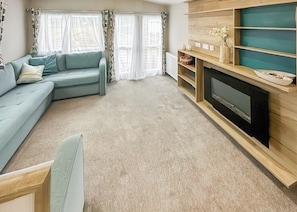 Ein Wohnzimmer mit einer Couch, einem Fernseher und einem Kamin.