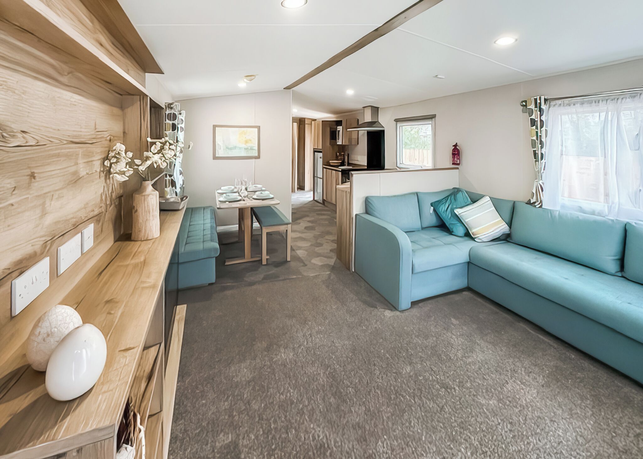 Een moderne woonkamer met een bank, een eettafel en een keuken op de achtergrond.