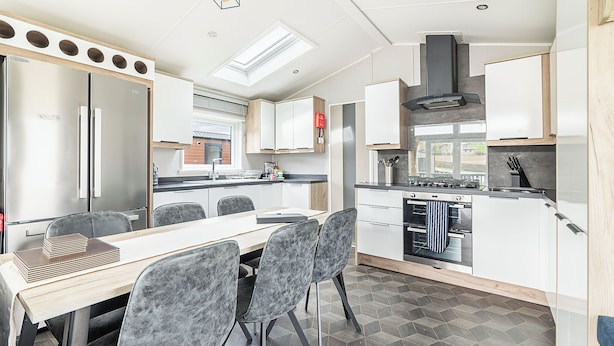 A modern kitchen with a dining area, featuring a built-in oven, a stove, and a skylight. - Modern two-bedroom lodge, perfect for couples or families. (Presteigne)