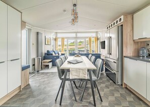Una cocina moderna con comedor, ventanas amplias y vistas al exterior.