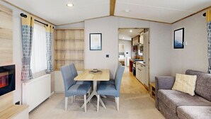 Un espacio habitable compacto con comedor, kitchenette y sofá.