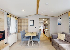 Ein kompakter Wohnraum mit Essbereich, Küchenzeile und einer Couch.