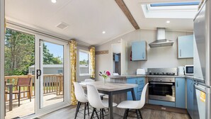 Una cucina moderna con zona pranzo, vista sull'esterno e piano cottura integrato.