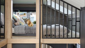 A modern interior with a staircase, a bed with patterned bedding, and a stuffed toy on the bed. - 1 bedroom accommodation in Arrochar (Arrochar)