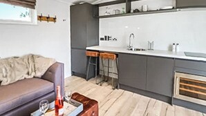 Una cocina moderna con barra, una mesa de comedor y un sofá en la sala.