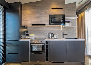 A modern kitchen with built-in appliances, a microwave, a coffee machine, and a toaster. - 1 bedroom accommodation in Millom (Millom)