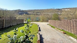 Un sendero de grava que lleva a un paisaje rural bajo un cielo despejado.