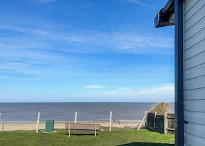 A view of the ocean from a house with a bench in the foreground. - 4 bedroom accommodation in Bacton-on-Sea (Bacton-on-Sea)