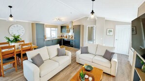 A modern living room with a sofa, coffee table, and dining area. - 2 bedroom accommodation in Market Bosworth, near Nuneaton (Market Bosworth, near Nuneaton)
