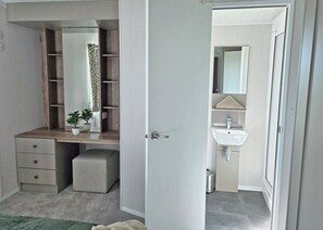 Un dormitorio con armario empotrado, mesita de noche y planta en maceta.