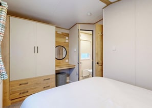 A bedroom with a bed, a wardrobe, a mirror, and a door leading to a bathroom. - Silver 2 Bedroom Pet (Crowle)