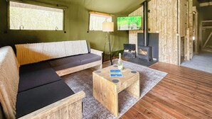 A cozy room with a sofa, a wooden coffee table, a fireplace, and a TV. - 1 bedroom accommodation in Halling (Halling)