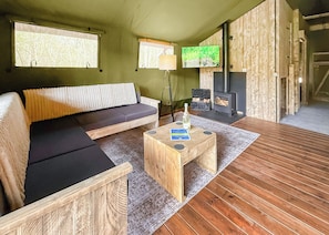 Ein gemütliches Zimmer mit einer Couch, einem Holztisch, einem Kamin und einem Fernseher.