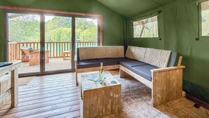 A wooden deck with a sofa and table, a sliding glass door to a deck area, and a green wall. - 1 bedroom accommodation in Halling (Halling)