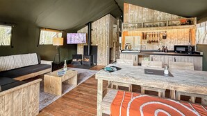 A cozy cabin interior with a sofa, wooden dining table, kitchen area, and a fireplace. - 1 bedroom accommodation in Halling (Halling)