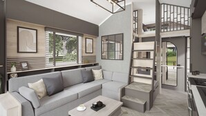 Un salon moderne avec un canapé gris, une table basse et un escalier menant à un niveau supérieur.