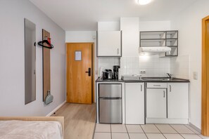 Eine kleine Küche mit Kühlschrank, Herd und Spüle.