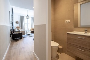 Een moderne badkamer met een houten wastafel, toilet en spiegel.
