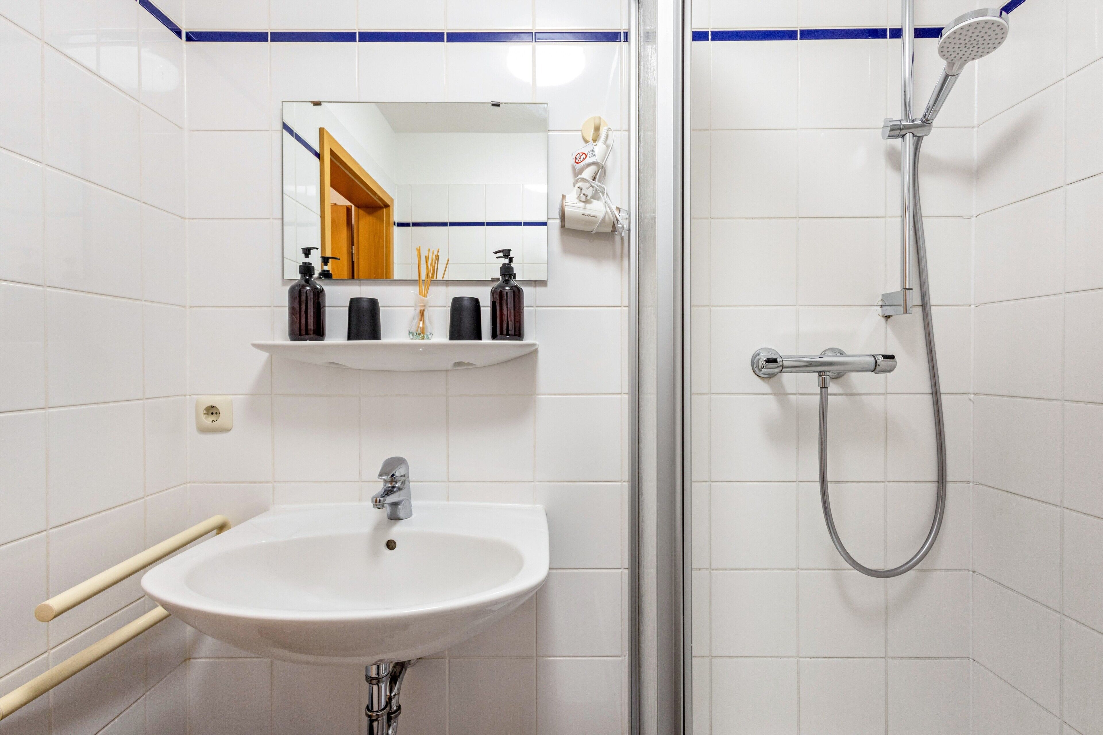 Ein Badezimmer mit Waschbecken, Spiegel und Dusche.