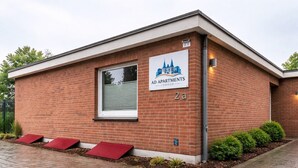 Tiilestä rakennettu rakennus, jonka yläpuolella on kyltti, jossa lukee: ”AD APARTMENTS FOBECH”.
