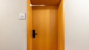 En trædør med håndtag, et skilt over døren og en lampe over døren.