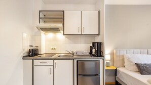 A compact kitchen with a sink, toaster, coffee maker, and a refrigerator. - Apartment '1-1' with Private Terrace, Private Garden and Wi-Fi (Lübeck)