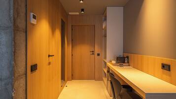 Una habitación de hotel moderna con una puerta de madera, un escritorio y una silla.
