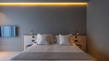 A modern bedroom with a large bed, two bedside tables, a wall-mounted TV, and ambient lighting.