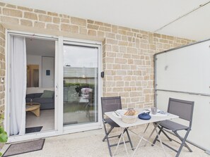 A patio area with a table, chairs, and a basket of bread.