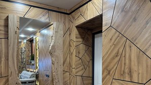 Un pasillo con paneles de madera y una cama al fondo.